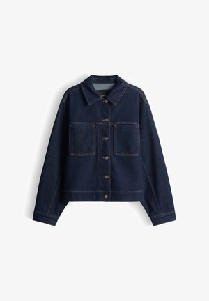 Giacca in denim blu scuro con design cropped, maniche lunghe, due tasche sul petto e bottoni color bronzo. Presenta cuciture arancioni a contrasto.