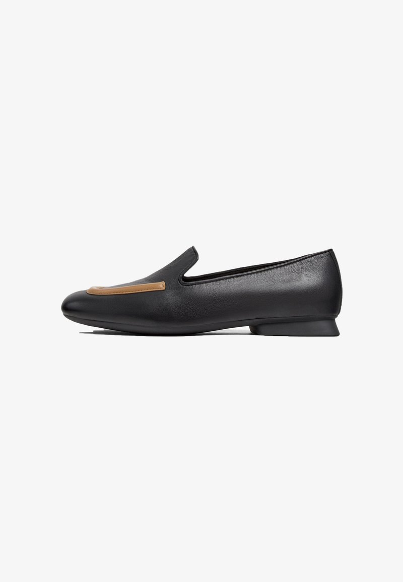 Black leather slip-on shoe with a low heel, featuring a tan leather accent on the vamp. Smooth texture and simple silhouette.
