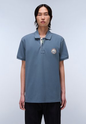 Grijze katoenen polo met een kraag, korte mouwen en een geborduurd embleem op de linkerkant van de borst. Voorzien van een knoopsluiting met twee knopen.
