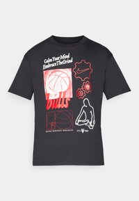 Camiseta de algodón negra con gráficos en rojo y blanco, que incluyen un balón de baloncesto, texto y logotipos. Manga corta y escote redondo.