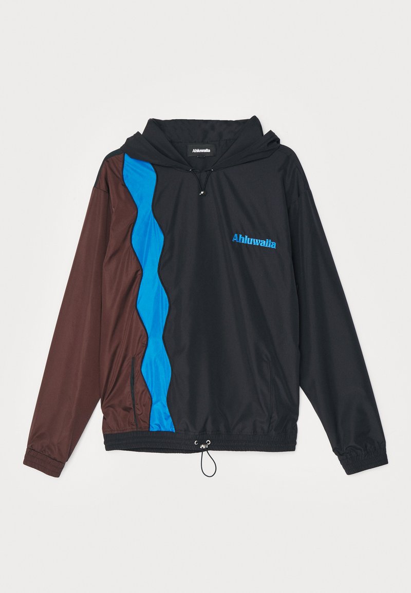 Veste coupe-vent noire, avec des panneaux latéraux ondulés marron et bleu. Équipée d'une capuche, de poignets élastiques et d'un ourlet ajustable avec cordon de serrage.