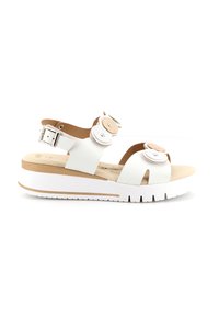 Sandali platform bianchi con design open toe, cinturino alla caviglia regolabile, accenti decorativi rotondi e una base beige a contrasto.