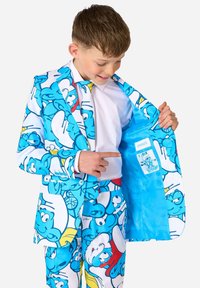 Blauwe pak met geanimeerde Smurfenpersonages. Het jasje heeft een levendige voering. De stof is glad met een speelse all-over print, gecombineerd met een bijpassende broek.