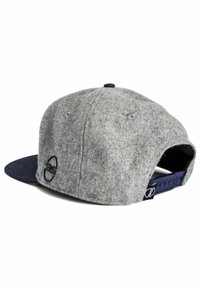 Gray wool blend cap with a navy flat brim. Features a stitched logo and adjustable snapback closure. Textured fabric with smooth accents.
