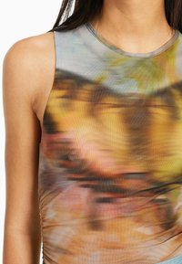 Hihaton paita, jossa on monivärinen abstrakti kuvio beige, keltainen ja harmaa sävyissä, sekä sileä, venyvä kangastuntuma.