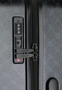 Schwarzer Hartschalenkoffer mit strukturierter Oberfläche, doppelten Reißverschlüssen, TSA-Schloss und Zahlenschloss. Marke "JOOP!" auf den Reißverschlussschiebern sichtbar.