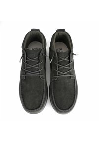 Zapatos de ante gris oscuro con punta redonda, parte superior texturizada y cordones planos. Presentan sutiles acentos de marca en la lengüeta y el talón.