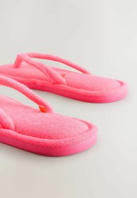 Lyserøde flip-flops med en blød, luksuriøs tekstur. Har en tyk sål og tynde stropper, designet til komfort og afslappet brug.