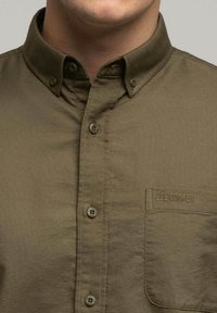 Kurtka w kolorze oliwkowym z kołnierzykiem, pięcioma guzikami, kieszonką na piersi z haftem "LEE COOPER" oraz gładką teksturą materiału.