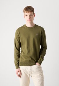 Olivgrüner Pullover aus Rippstrickmaterial, mit einem runden Halsausschnitt und lässiger Passform, versehen mit einem kleinen gestickten Logo auf der Brust.