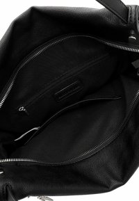 Black leather handbag interior with a smooth texture, zippered compartments, and a fabric lining, featuring silver-tone hardware accents.