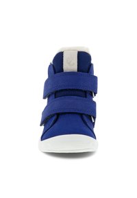 Blå hög sneaker med två kardborreband, texturerad tygutsida och vit gummisula. Polstrad krage och mjuk foderdetalj.