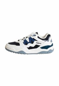 Scarpa sportiva bianca con accenti blu navy e grigio, realizzata in materiali in rete e pelle, suola testurizzata e lacci intrecciati in un design moderno e atletico.