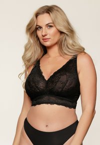 Sorte blonde bralette med v-hals og blomstermønster, med en bred elastic band og justerbare stropper, parret med matchende sorte trusser.