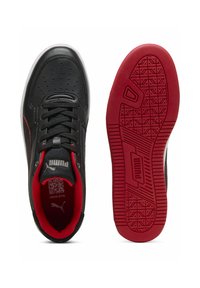 Sneaker in pelle nera con dettagli rossi, dotate di una colletto imbottito, chiusura con lacci frontale e una suola in gomma con un motivo rosso testurizzato.