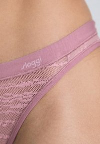 Pink lace brief featuring a soft fabric waistband and a patterned mesh overlay. The brand name "sloggi" is subtly displayed on the waistband.