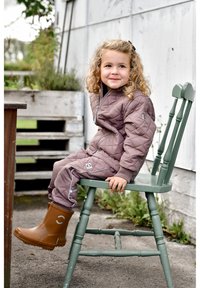 Bruine gewatteerde jas en broek met lichtgrijze accenten, gedragen met bruine rubberen laarzen. Kind zittend op een groene houten stoel buiten.