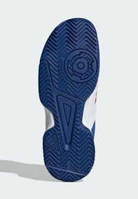 La semelle de la chaussure est en caoutchouc bleu avec un motif en chevron, des accents blancs et un logo circulaire. Conception anti-traces pour les surfaces intérieures.