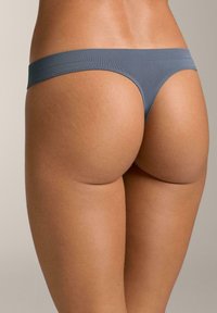 Tanga grigio senza cuciture realizzato in un materiale morbido ed elasticizzato, con vita bassa e copertura posteriore ridotta per un fit elegante.