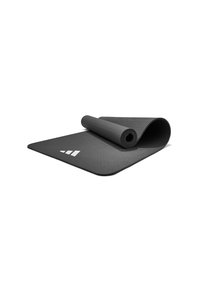 Esterilla de yoga negra con superficie texturizada, enrollada parcialmente. Presenta un logo geométrico blanco en una esquina. Material suave y duradero, forma rectangular.