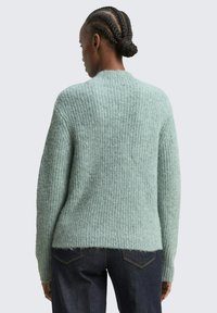 Hellgrüner, strukturierter Strickpullover mit einem gerippten Muster, Rundhalsausschnitt und leicht lockerer Passform. Endet auf Hüfthöhe.