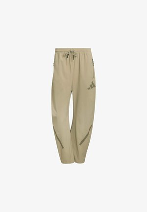 Pantaloni sportivi beige con vita elastica, coulisse, tasche laterali e dettagli riflettenti grigi. Realizzati in tessuto leggero e liscio.