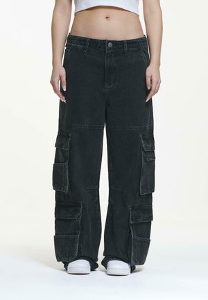 Zwarte cargobroek met een losse pasvorm, meerdere zakken en een licht vervaagde textuur. Sluit met een knoop en heeft een elastische tailleband.