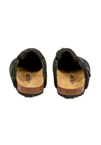 Des chaussures noires à enfiler avec une tige en feutre doux et une semelle en liège. L'intérieur est en matériau beige clair avec le texte "42 BILLY". Pas de matériel visible.