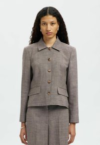Blazer aderente in tweed marrone con colletto, chiusura a bottoni e due tasche frontali. Presenta un tessuto testurizzato e bottoni in legno naturale.