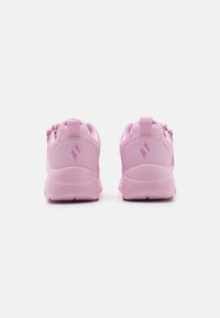 Scarpe da ginnastica rosa realizzate in un materiale sintetico liscio. Le caratteristiche includono un colletto imbottito, una suola testurizzata e un logo riflettente sul retro.
