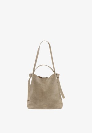 Beige ruskind skuldertaske med to håndtag, en lang rem og en kort, med et diskret mærkenavn nær bunden.