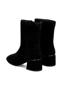 Botas de tobillo de ante negro con punta afilada, cierre de cremallera en la parte posterior y un tacón cuadrado con un acento metálico.