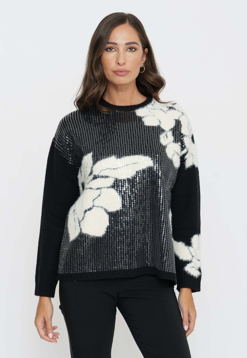 Maglione nero con un design floreale in paillettes bianche, tessuto morbido e texture, e scollo rotondo. Maniche lunghe e vestibilità rilassata.