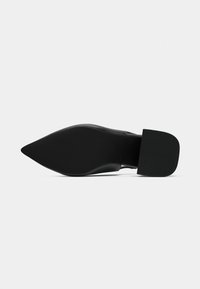 Chaussure noire à bout pointu avec un dessus lisse, talon plat et semelle en caoutchouc. Design minimaliste avec une finition mate et sans ornements visibles.
