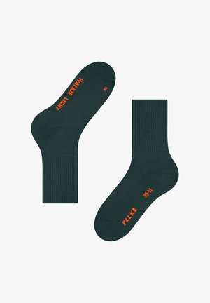 Chaussettes vert foncé avec texture côtelée, portant les inscriptions "WALK LIGHT" et "FALKE" en orange. Comprend des étiquettes gauche (L) et droite (R).