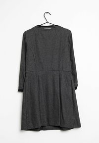 Vestido gris con estampado, de manga larga, con escote redondeado y falda acampanada. Presenta un ribete negro sólido en los puños.