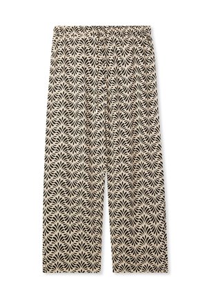 Pantaloni ampi e fluidi in un tessuto crema con un motivo a foglia nera ripetuto. Vita elastica per comfort e facilità di indossarlo.