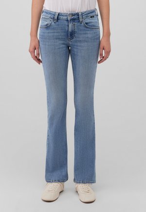 Light blue denim flared jeans with a mid-rise waist, front pockets, and contrast stitching. Worn with neutral sneakers.