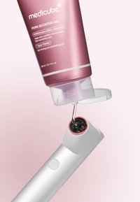 Żel PDRN Booster od Medicube w różowej tubie, dozujący żel do białego aplikatora z czerwonym akcentem. Gładka powierzchnia, przezroczysta zakrętka.