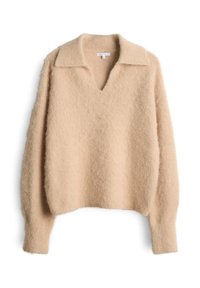 Maglione beige chiaro realizzato in materiale morbido e soffice. Presenta un collo a V, un colletto piatto e maniche leggermente oversize. Superficie strutturata.