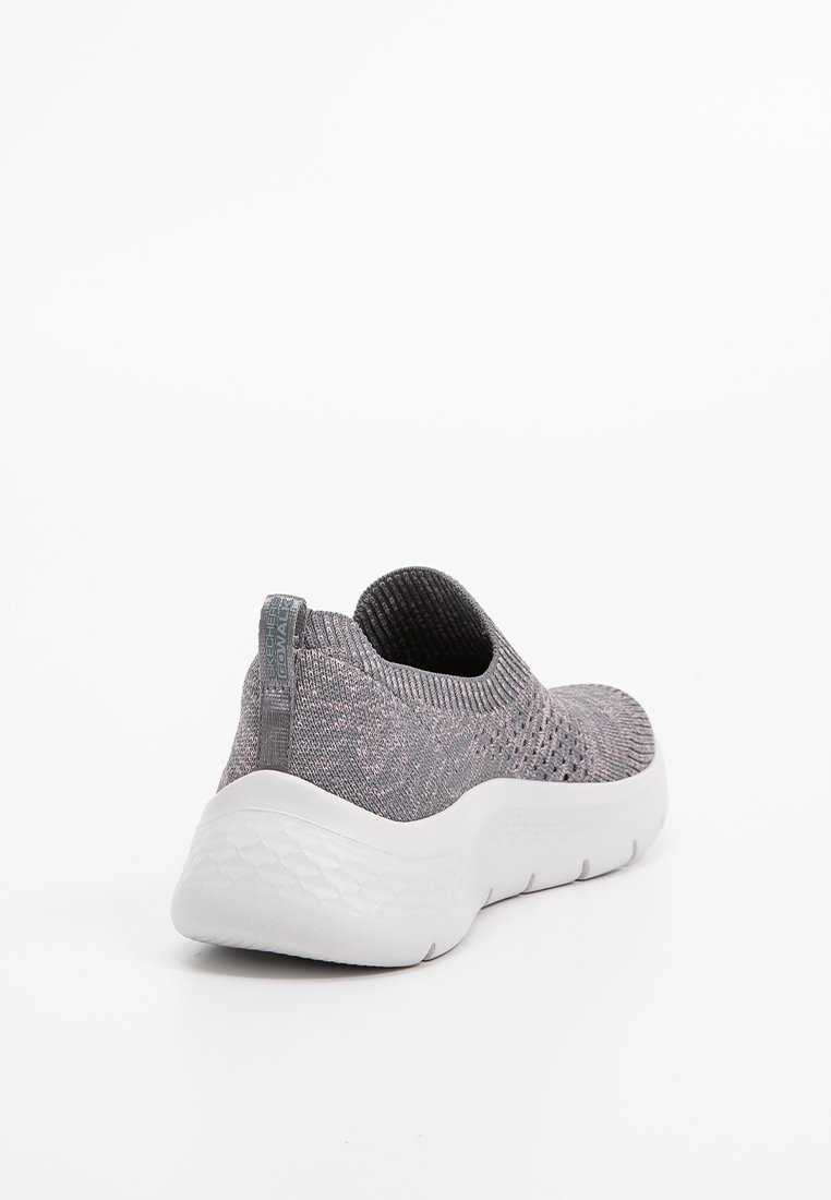 Graue Slip-On-Sneaker mit gestricktem Obermaterial und dicker, strukturierter weißer Sohle, von der Rückseite auf weißem Hintergrund gezeigt.