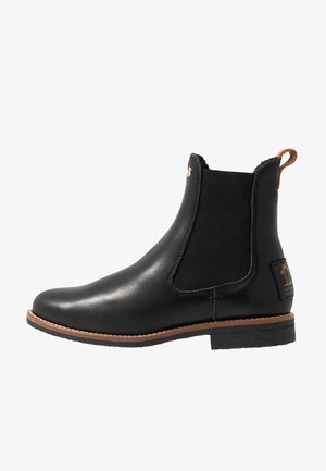 Botín Chelsea negro de cuero con paneles laterales elásticos, puntera redonda y suela de goma texturizada. Presenta una pequeña lengüeta y costuras decorativas.