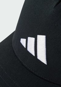 Gorra negra hecha de tejido texturizado que presenta un logo bordado en blanco con tres barras anguladas en la parte frontal.