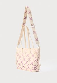 Bež vrečka za nošenje z vijoličnimi cvetličnimi motivi in črko V, z dvema ročajema, snemljivo naramnico in zlato obarvanimi kovinskimi dodatki.