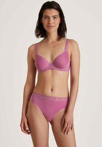 Roze lingerie set met een gepadded bh met kantdetails en bijpassende slip met een kanten band. Glad textuur, vrouwelijke design.