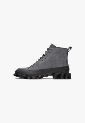Gray high-top boot with a rounded toe and textured rubber sole. Features laces, a pull tab, and smooth suede upper. Suitable for casual wear.