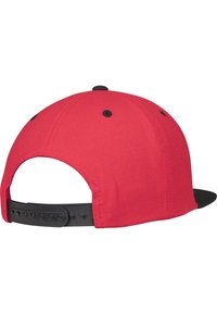 Punane kork musta äärega, valmistatud kangast. Seljaosas on nupuvajutusega sulguri ja kuus ventilatsiooniava. Puhtad jooned, ilma mustrite ja logodeta.