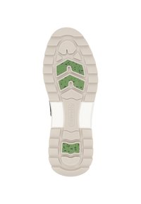 Sneaker sole featuring a beige rubber base with green accent pieces, textured treads, and a patterned design for grip and stability.