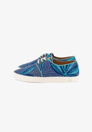 Baskets basses bleues avec lacets blancs, présentant des motifs de feuilles turquoise et des semelles en caoutchouc blanches sur fond blanc.
