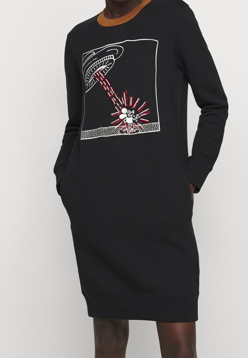 Svart sweatshirtklänning med långa ärmar, med en brun krage och ett grafiskt tryck av en UFO som strålar ner röda och vita strålar.